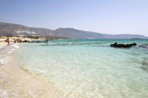 a beach with a group of people in the water at Mouri Village in Aïkiryiánnis