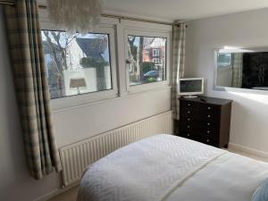 a bedroom with a bed and a window at 'Sounion' - Fabulous, spacious modern house with large private garden in Leafy Lytham in Lytham St Annes