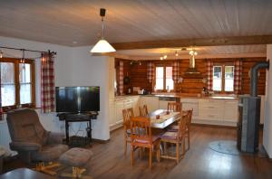 cocina y comedor con mesa y TV en Ferienhaus Ederhof - Idyllischer Vierseithof, kinder- und hundefreundlich, Referenzen auf FeWo-direkt nachlesbar, en Aidenbach