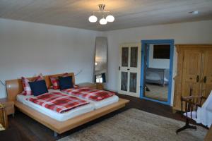 a bedroom with a large bed and a bathroom at Ferienhaus Ederhof - Idyllischer Vierseithof, kinder- und hundefreundlich, Referenzen auf FeWo-direkt nachlesbar in Aidenbach