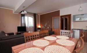 un soggiorno con tavolo in legno e divano di Apartmany Sileas a Veľká Lomnica