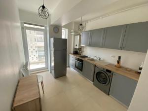 a kitchen with a refrigerator and a washer and dryer at Apartament Park View Campus in Constanţa