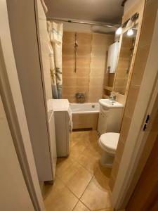 uma casa de banho com um WC, um lavatório e uma banheira em Slomiana Apartment em Cracóvia