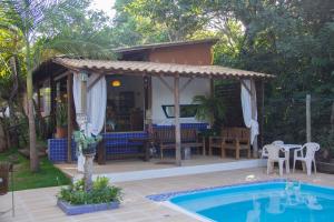 a house with a swimming pool and a patio at Vila Flores Pousada in Serra do Cipo