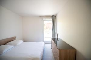 a bedroom with a bed and a dresser and a window at Appartements de 2 ou 3 chambres à 40 minutes de Paris in Evry-Courcouronnes +14 photos