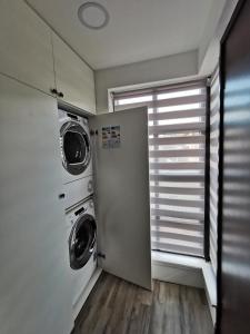 a laundry room with a washer and dryer next to a window at LOLO PROPERTIES 2, Free Parking in Edinburgh