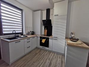una cucina con armadi bianchi, lavandino e frigorifero di LOLO PROPERTIES 2, Free Parking a Edimburgo