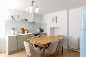 a kitchen and dining room with a wooden table and chairs at Luxe Design - Chic Cottage - Heart of Rothbury in Rothbury
