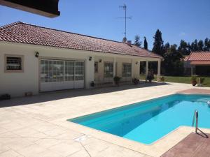 a swimming pool in front of a house at Casa da Nelita in São Martinho do Porto