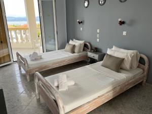 two beds in a room with a balcony at Sweet Dreams in Kavos