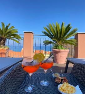 two wine glasses sitting on a table on a balcony at Allegroitalia Alassio Rosa in Alassio