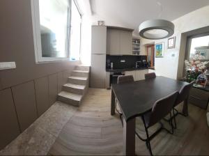 a dining room with a table and chairs and a kitchen at Skipper in Piran
