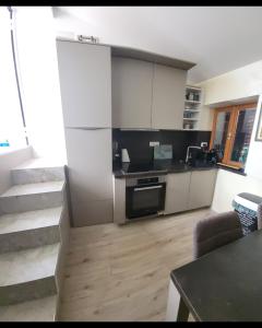 a kitchen with white cabinets and a stove top oven at Skipper in Piran +14 photos
