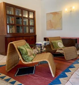 2 sillas de mimbre y una mesa en la sala de estar. en Gubbio-Gualdo Tadino Incantevole mansarda con terrazza, en Gualdo Tadino