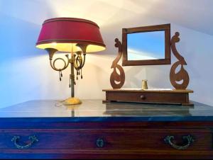 una lámpara en la parte superior de un tocador con espejo en Gubbio-Gualdo Tadino Incantevole mansarda con terrazza, en Gualdo Tadino