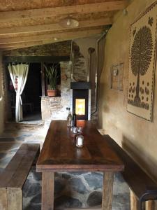 una mesa de madera en una habitación con chimenea en Albergue Eco El Beso - Vegano, en Triacastela