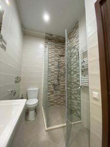 y baño con ducha, aseo y lavamanos. en Lovely and cozy apartment! en Kutaisi