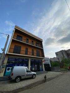 a van parked in front of a building with a dog at Lovely and cozy apartment! in Kutaisi