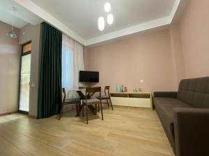 uma sala de estar com um sofá e uma mesa em Lovely and cozy apartment! em Kutaisi