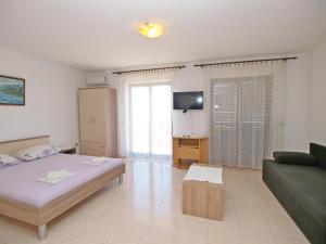 a living room with a bed and a couch at Apartmani Korljan in Gradac