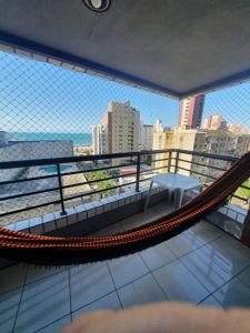 un balcón con hamaca y vistas a la ciudad en Praia Mansa Suíte Hotel, en Fortaleza