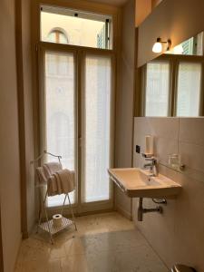 La salle de bains est pourvue d'un lavabo et d'une fenêtre. dans l'établissement Dimora 4 Spade, à Vérone