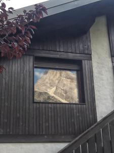 uma janela numa casa com uma montanha ao fundo em Casa Antelao em San Vito di Cadore