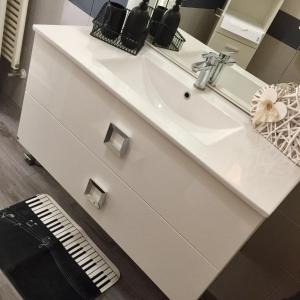 La salle de bains est pourvue d'un lavabo blanc et d'un miroir. dans l'établissement LA CHIAVE DI VIOLINO Appartamentino musicale, à Bologne