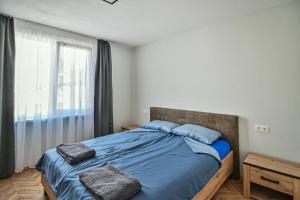 House Stavrevi في مدينة فارنا: غرفة نوم بسرير وملاءات زرقاء ونافذة