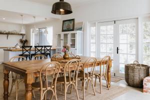 a kitchen and dining room with a wooden table and chairs at Drift House in Quindalup