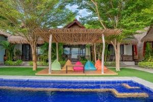 a group of colorful chairs next to a swimming pool at Krisna Bungalows and Restaurant in Sekotong