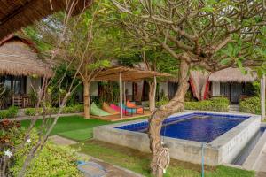a resort with a swimming pool and a tree at Krisna Bungalows and Restaurant in Sekotong