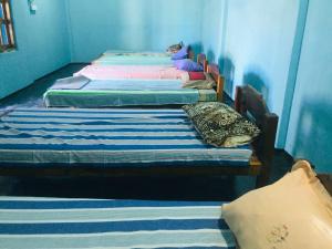 un grupo de 3 camas en una habitación en Moon Eyes Beach Hotel, en Arugam Bay