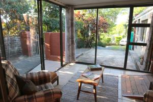 un soggiorno con porte in vetro e un tavolino da caffè di 17 HAWKES HEAD SELF CATERING a East London