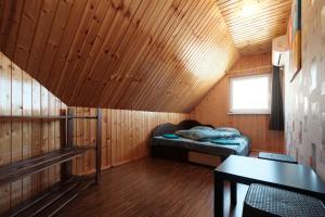 um pequeno quarto com uma cama num chalé de madeira em Jaukus Kampelis em Zarasai