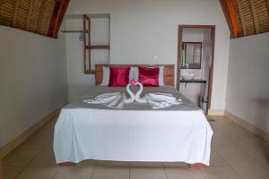 a bed with two swans made out of towels at Krisna Bungalows and Restaurant in Sekotong