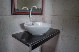 a bathroom with a white bowl sink on a black counter at Krisna Bungalows and Restaurant in Sekotong