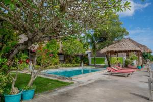 a villa with a swimming pool and a gazebo at Krisna Bungalows and Restaurant in Sekotong
