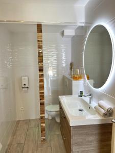 a bathroom with a sink and a mirror and a toilet at Hôtel Beau Soleil in Le Lavandou