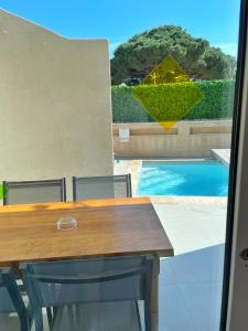 a dining room table with a view of a swimming pool at Hôtel Beau Soleil in Le Lavandou