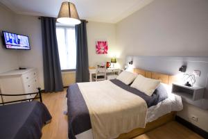 1 dormitorio con 1 cama y TV en Chambres Chez Laurence, en Kaysersberg