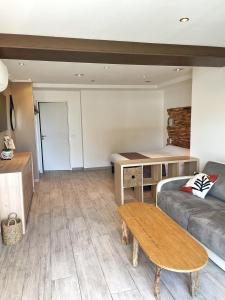 a living room with a couch and a table at Hôtel Beau Soleil in Le Lavandou