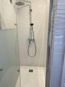 a shower with a glass door in a bathroom at Hôtel Beau Soleil in Le Lavandou