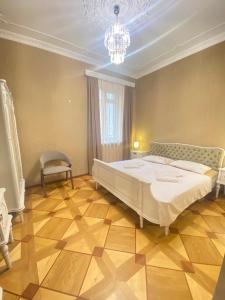 a bedroom with a large white bed and a chandelier at K&N Guesthouse in Tbilisi City