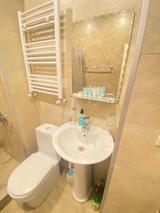 a bathroom with a white toilet and a sink at K&N Guesthouse in Tbilisi City