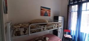 カステッランマーレ・デル・ゴルフォにあるBovio guest Houseの小さなベッドルーム(二段ベッド1台、椅子付)