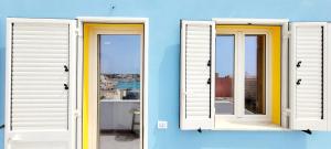 a pair of doors on a blue wall at Il maestro di nodi - Casa vista mare in Lampedusa +44 photos