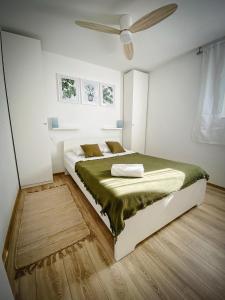 sypialnia z łóżkiem i wentylatorem sufitowym w obiekcie Casa Martinica - House with 2 Apartments w mieście Ližnjan