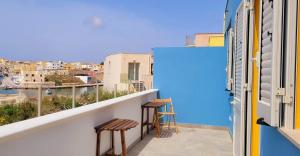 a balcony with two chairs and a view of a city at Il maestro di nodi - Casa vista mare in Lampedusa