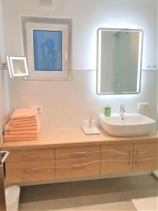 ein Bad mit einem Waschbecken und einem Spiegel in der Unterkunft Haus am Weinberg in Seekirchen am Wallersee